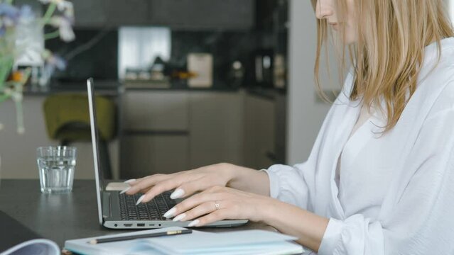 Close up of female hands typing on keyboard of laptop, working from home or hotel. Woman using computer, having remote work on distance