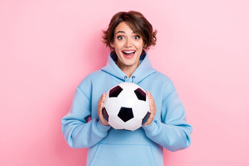 Portrait photo of young attractive gorgeous nice girl hold football ball soccer fan professional player competition isolated on pink color background