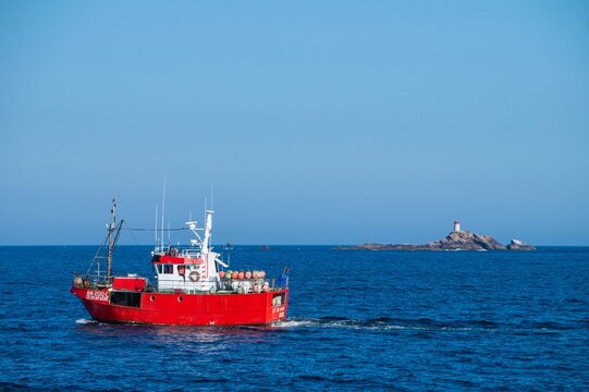 A red boat that constrast with blue sea