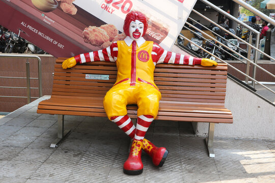 Clown sits on a bench in Mangalore, India, January 28, 2020. McDonald's fast-food restaurant.