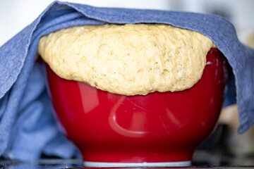 Bread dough rising and yeasting in a kitchen bowl.