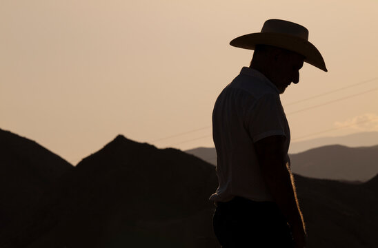 Silhouette of adult man in cowboy hat in desert during sunset. Almeria, Spain
