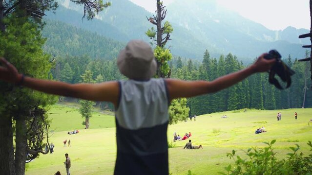 A man with open arms in Baisaran Valley( Mini Switzerland) Pahalgam, Kashmir, India.