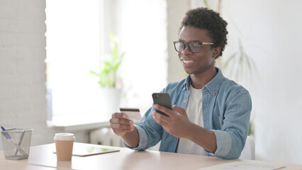 Young African Man Shopping Online on Smartphone