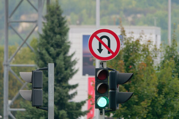 No U-Turn Sign and a traffic light attached to a metal pole 