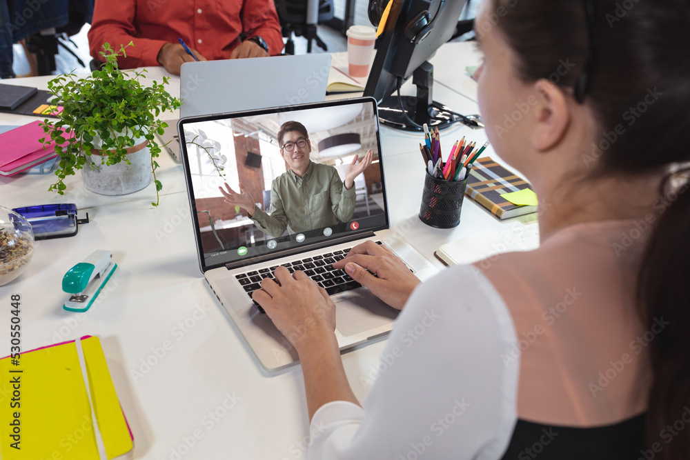 Sticker Caucasian businesswoman making laptop video call with asian male colleague on screen