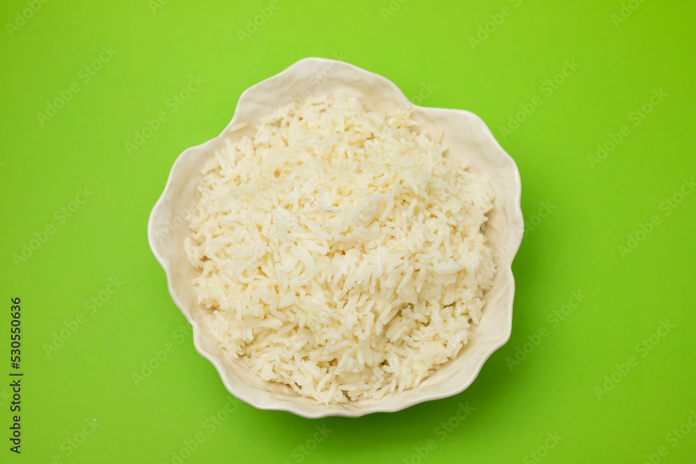 Poster white boiled rice in beautiful bowl on green