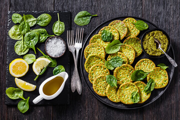 spinach pancakes on black plate with basil pesto