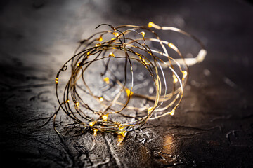 Fairy lights led garland coil, blurred, on a black background. Christmas atmosphere concept