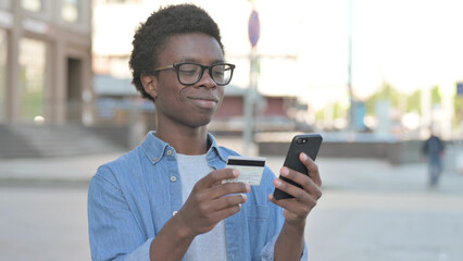Young African Man Shopping Online via Smartphone, Outdoor