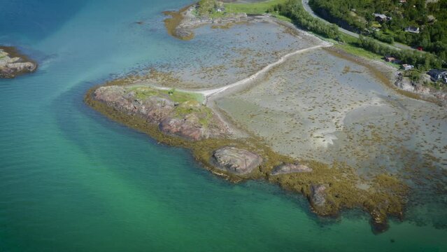 Drone circling the small island of Rodholmen with mountains in the back