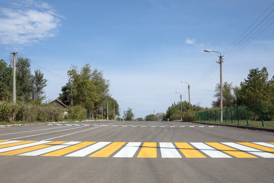 A view on the background of a yellow and white surface plastered on a zebra crossing on a concrete road in rural Russia for walking to the opposite side.