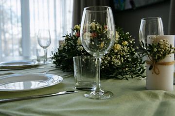 in a bright room, with daylight, a festive table is decorated, with plates and glasses