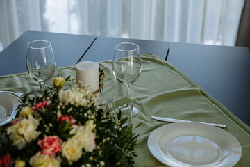 in a bright room, with daylight, a festive table is decorated, with plates and glasses