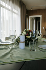 in a bright room, with daylight, a festive table is decorated, with plates and glasses