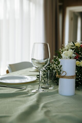 in a bright room, with daylight, a festive table is decorated, with plates and glasses