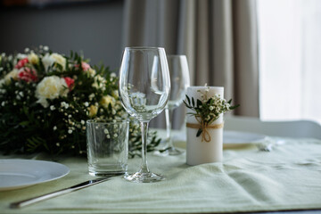 in a bright room, with daylight, a festive table is decorated, with plates and glasses