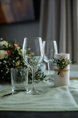 in a bright room, with daylight, a festive table is decorated, with plates and glasses