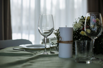 in a bright room, with daylight, a festive table is decorated, with plates and glasses