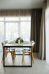 in a bright room, with daylight, a festive table is decorated, with plates and glasses