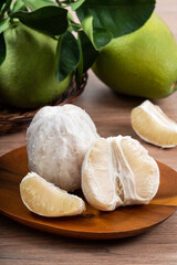 Fresh pomelo fruit on wooden table background.