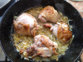 Fried chicken legs in a pan close-up.