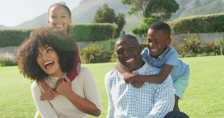 Video of happy african american family spending time together in the garden