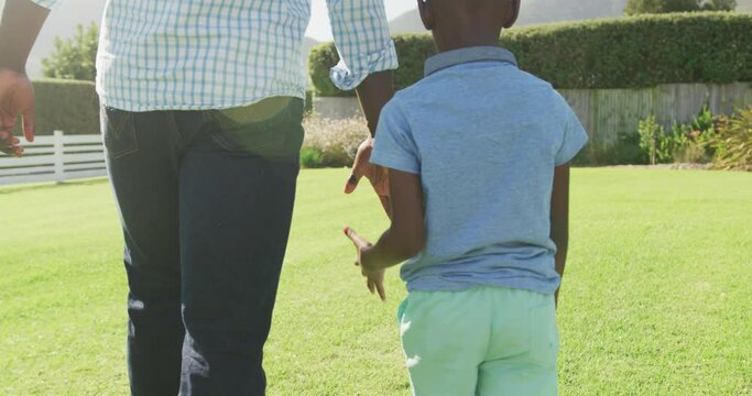 Video of happy african american family spending time together in the garden