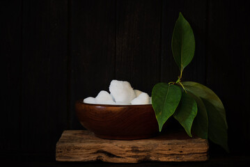 Camphor crystal and ngai camphor branch green leaves on an old wood background.
