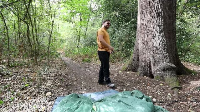 Cool man with sunglasses gets angry when fails to assemble tent in forest