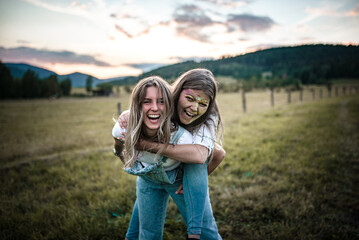 Two blonde girls are having fun with holi powder on a nice sunny evening.