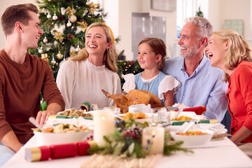 Multi-Generation Family Celebrating Christmas At Home Eating Meal Together Around Table