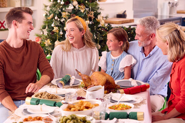 Multi-Generation Family Celebrating Christmas At Home Eating Meal Together Around Table