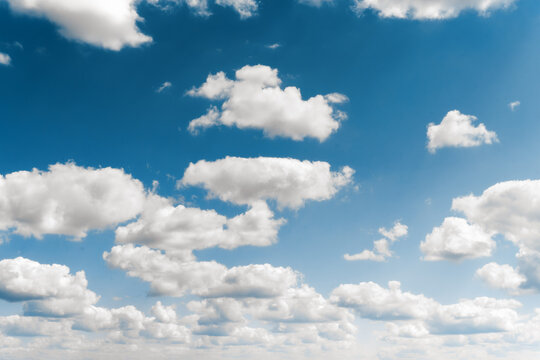 Beautiful blue sky with white fluffy clouds. Natural background. Nice weather, clear summer sky