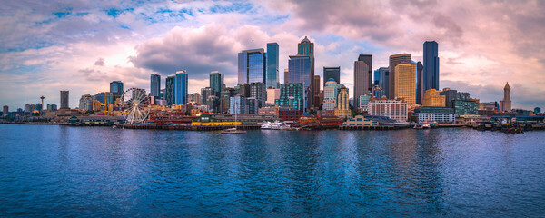 Seattle city skyline at sunset, dramatic cloudscape, and the vista of the metropolitan downtown financial district over Elliot Bay in Washington State - obrazy, fototapety, plakaty