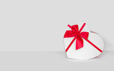 white box with a red bow present on light background with copy space