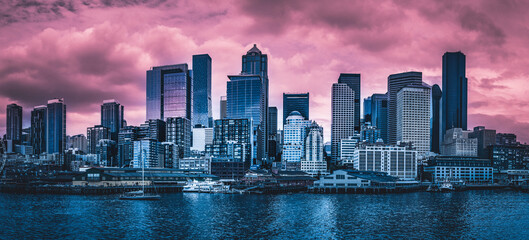 Dramatic Seattle city skyline at sunset with pink clouds in the sky over Elliot Bay in Washington State, USA
