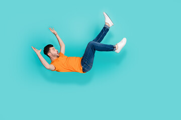 Full size photo of young handsome excited funny man slipped floor unexpected falling down wet isolated on aquamarine color background