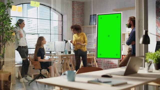 Expressive Project Manager Talking on a Team Meeting in Creative Agency Conference Room. Arab Female Showing Business Plan Presentation on Green Screen Mock Up Chroma Key Monitor.