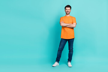 Fototapeta na wymiar Full body size photo of young handsome confident positive man wear stylish outfit folded hands smiling empty space new shopping mall isolated on cyan color background