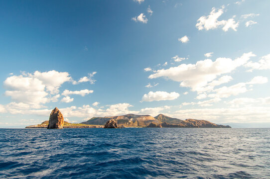 The stromboli vulcano erupting on the "Sciara del Fuoco"(path of lava) day panoramic shot, blue sky background, eolians islands, sicily, italy.
