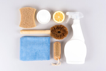 Natural simple homemade household cleaners - baking soda, lemon, citric acid, spray bottle over gray background. Bio organic detergent products. Green household concept