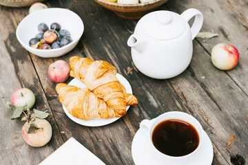 wooden table drinking tea after harvesting in autumn in back yard, fall and harvest, zero waste life, eco-friendly simple living, apples, croissant