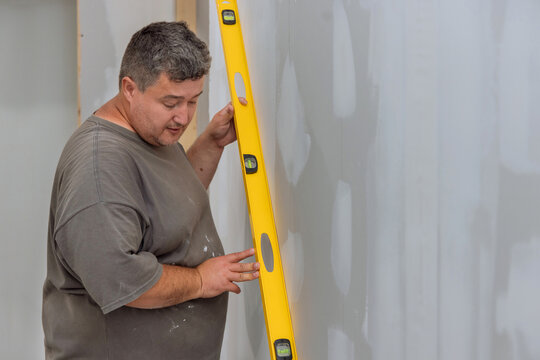 In Order To Ensure That A Wall Of Drywall Is Level Before It Is Painted, The Employee Uses Level