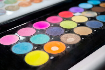 Naklejka premium Colorful eyeshadow pallet for make up in cosmetic store - close up view. Makeup, beauty, fashion and glamour concept