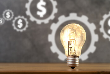 Close up photo of dollar sign and shining light bulb in one frame as a symbol of startup, investing money, target and business idea.