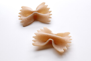 small composition of whole durum wheat pasta on a white background