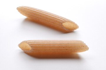 small composition of whole durum wheat pasta on a white background
