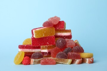 Pile of delicious bright jelly candies on light blue background