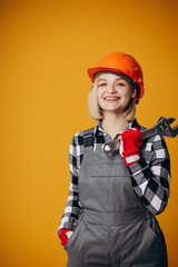 Woman builder in hard hat holding french key tool